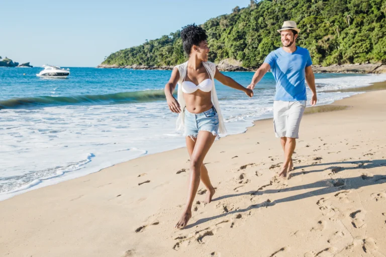 An active retired couple running joyfully on a Panama beach