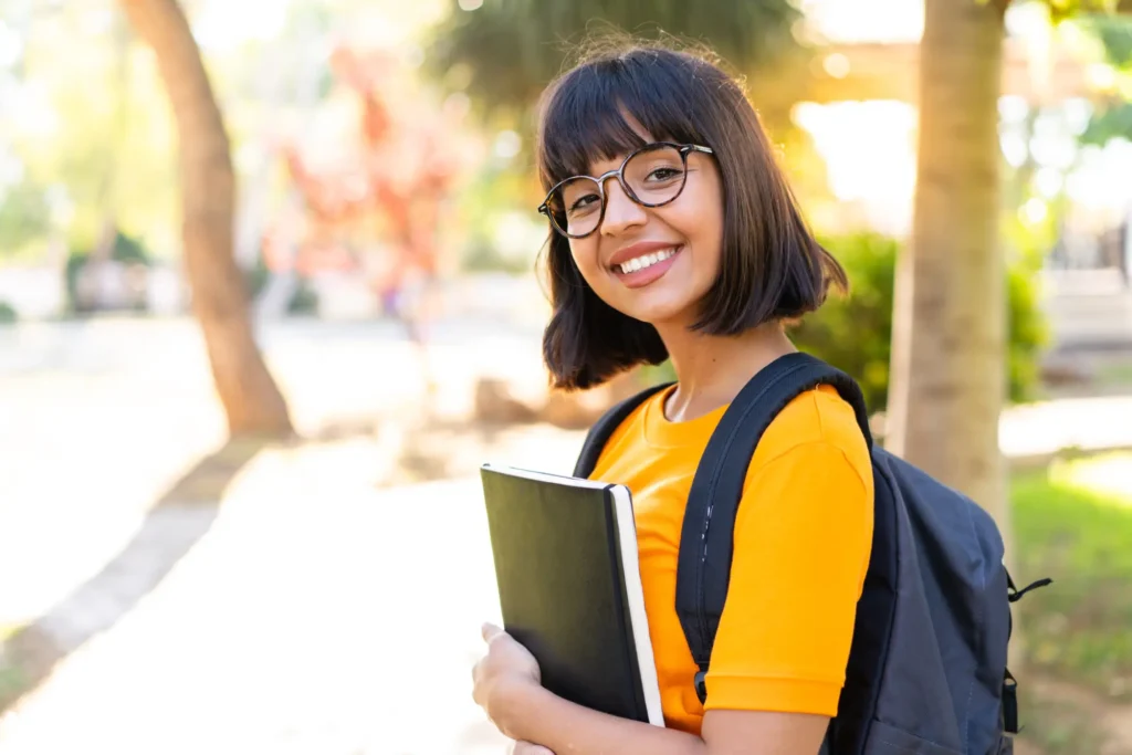 Young student woman win park holding notebook