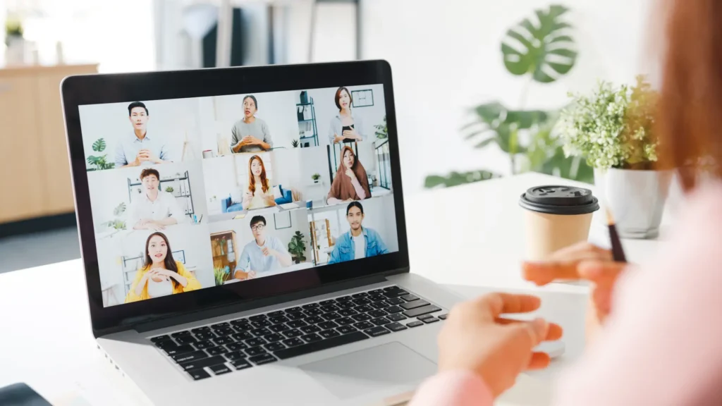 Young asia businesswoman using laptop talk colleague about plan video call meeting while work from home living room