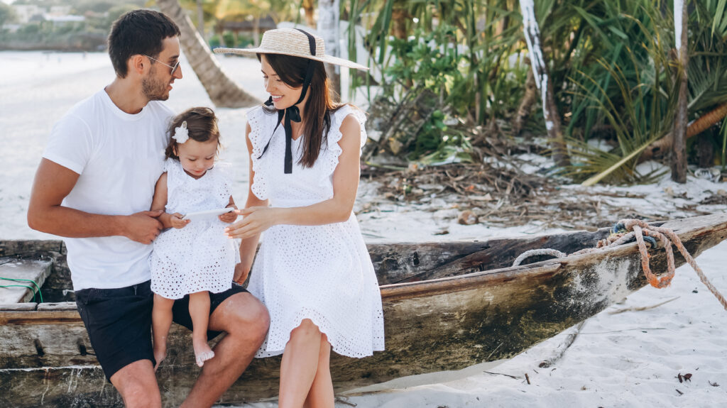 Young family with little daugher on a vacation by the ocean